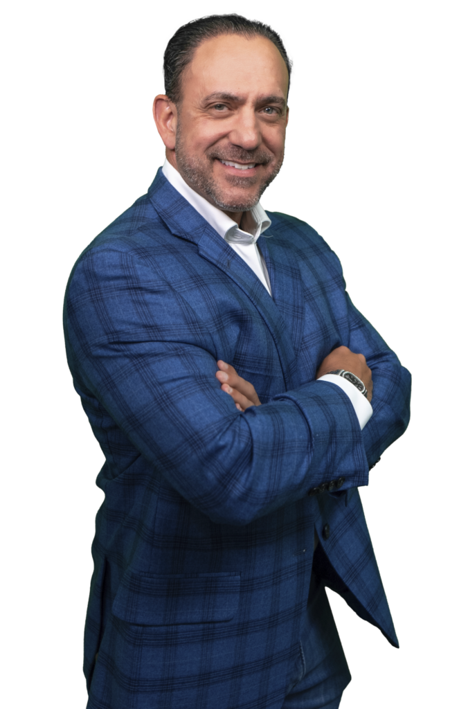Smiling man in a blue plaid suit with arms crossed, facing the camera against a black background